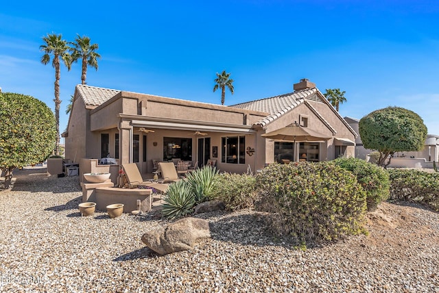 back of house featuring stucco siding, a tile roof, a ceiling fan, and a patio