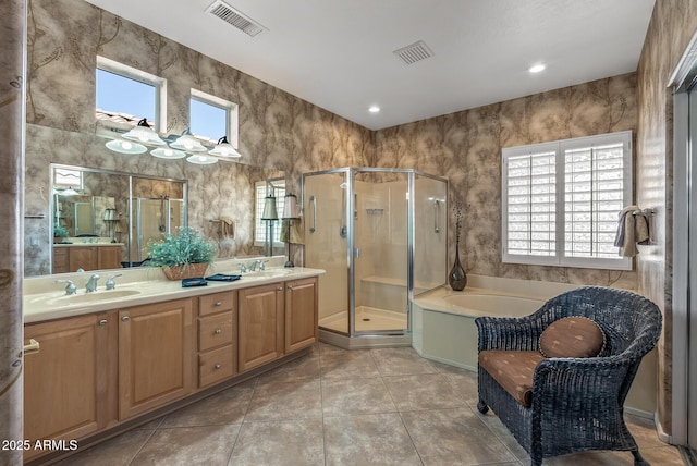 bathroom featuring a stall shower, a sink, visible vents, and a healthy amount of sunlight