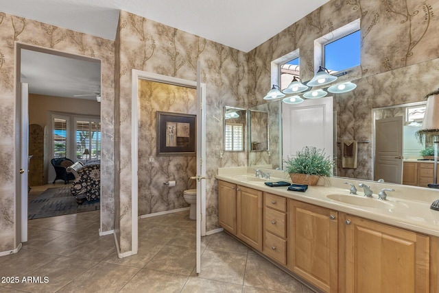 full bath featuring double vanity, toilet, ensuite bathroom, a sink, and tile patterned floors