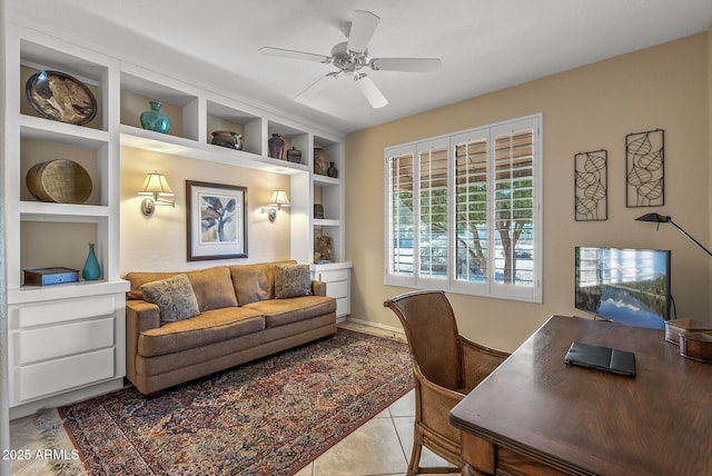 office with light tile patterned floors, built in shelves, and a ceiling fan