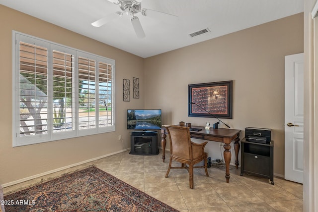 office space with visible vents, ceiling fan, baseboards, and light tile patterned floors