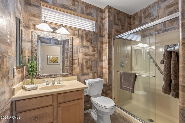 bathroom featuring a shower stall, vanity, and toilet