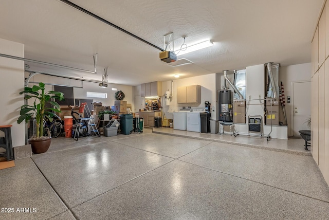 garage featuring a garage door opener, gas water heater, and separate washer and dryer