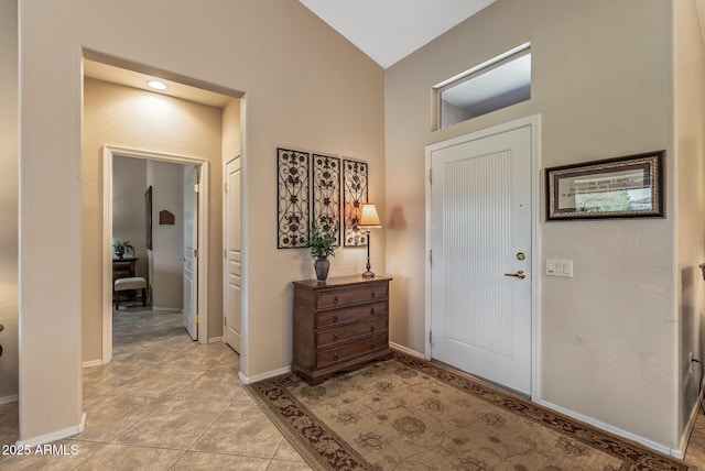 foyer with light tile patterned floors and baseboards