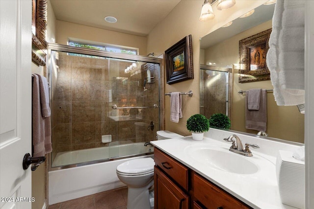 full bathroom featuring vanity, bath / shower combo with glass door, toilet, and tile patterned floors