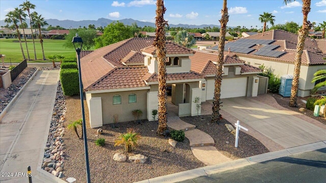 mediterranean / spanish house featuring a mountain view, a garage, and a front lawn