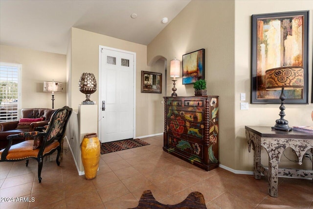 tiled foyer entrance featuring lofted ceiling