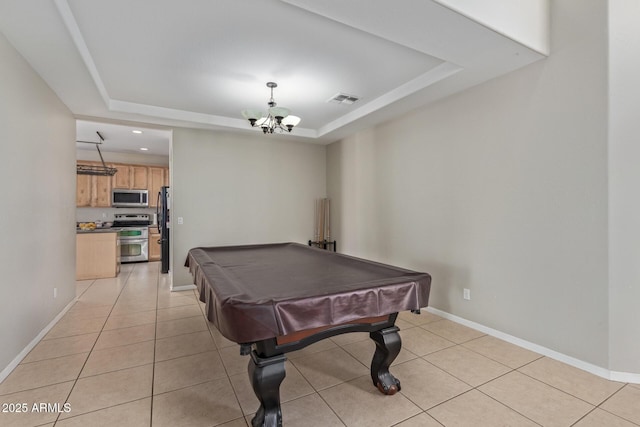 game room featuring a tray ceiling, light tile patterned floors, and baseboards