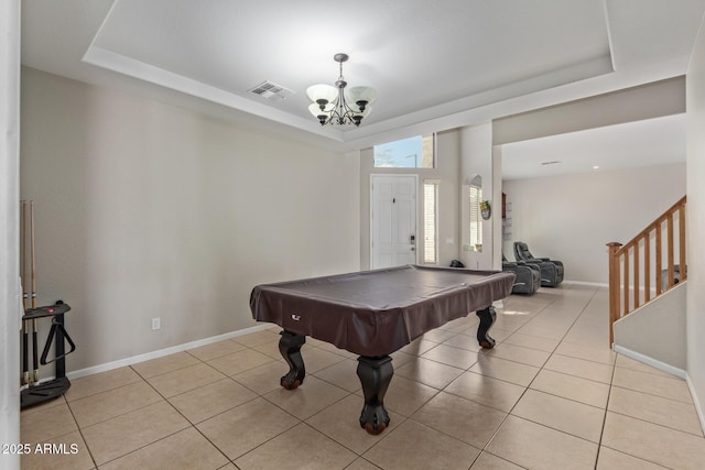 rec room featuring a raised ceiling, a chandelier, light tile patterned flooring, and baseboards