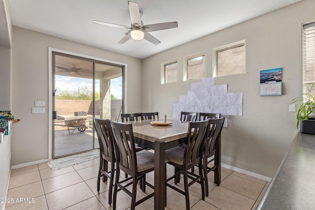 dining space featuring baseboards, ceiling fan, and light tile patterned floors