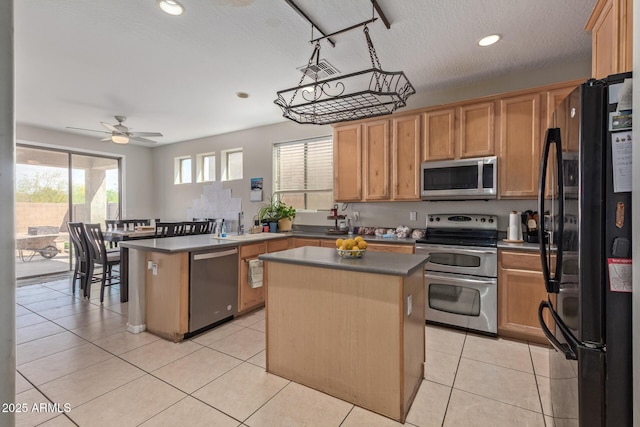 kitchen with stainless steel appliances, a peninsula, recessed lighting, a center island, and ceiling fan