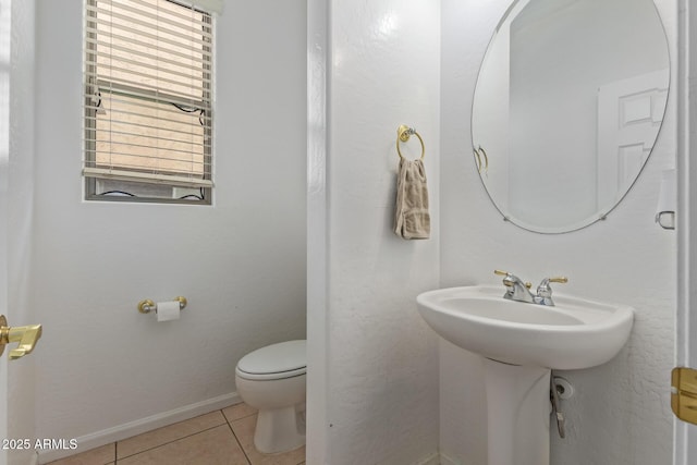 half bath featuring toilet, tile patterned flooring, and baseboards