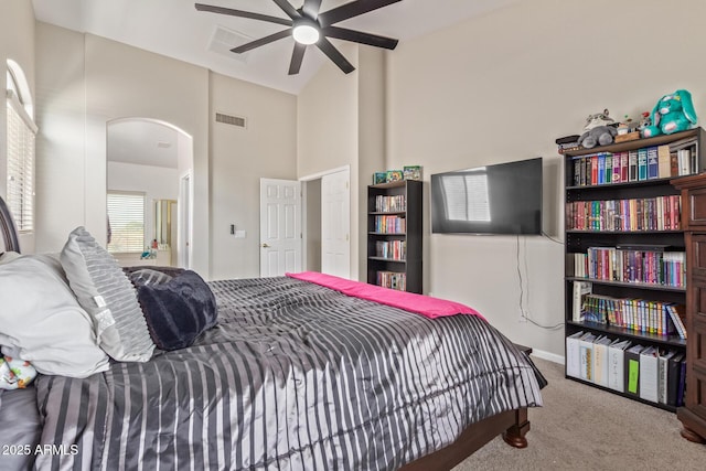 bedroom with carpet, arched walkways, high vaulted ceiling, and a ceiling fan