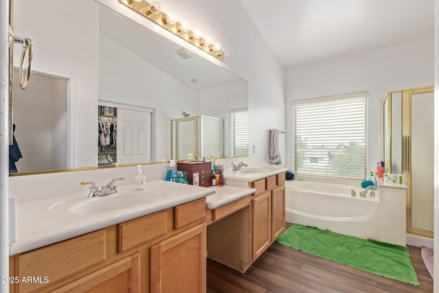 bathroom with a shower stall, wood finished floors, a garden tub, vanity, and high vaulted ceiling