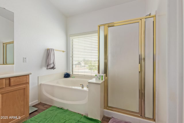 bathroom with a garden tub, a shower stall, vanity, and wood finished floors