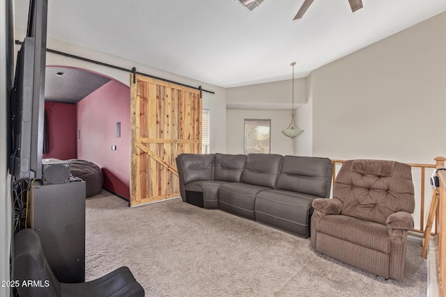 carpeted living room featuring a ceiling fan, a barn door, lofted ceiling, and arched walkways