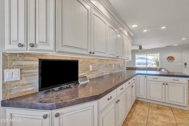 kitchen featuring white cabinetry, crown molding, and kitchen peninsula