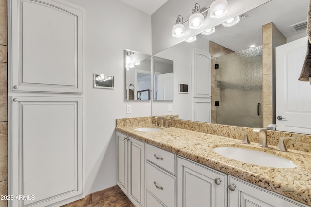 bathroom featuring a shower with door and vanity