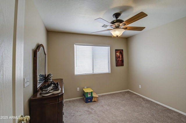 interior space with baseboards, carpet floors, visible vents, and a ceiling fan