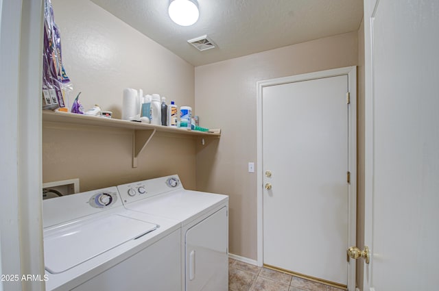 laundry area with visible vents, a textured ceiling, washing machine and dryer, light tile patterned floors, and laundry area