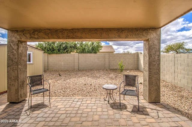 view of patio / terrace with an outdoor structure, a fenced backyard, and a shed