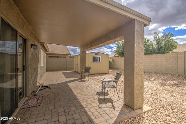 view of patio featuring a storage unit, an outbuilding, and a fenced backyard