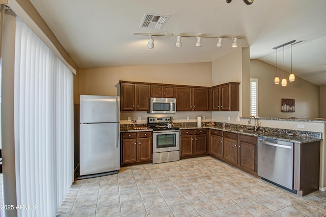 kitchen with visible vents, dark stone countertops, a sink, stainless steel appliances, and lofted ceiling