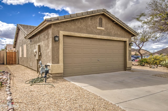 garage with driveway and fence