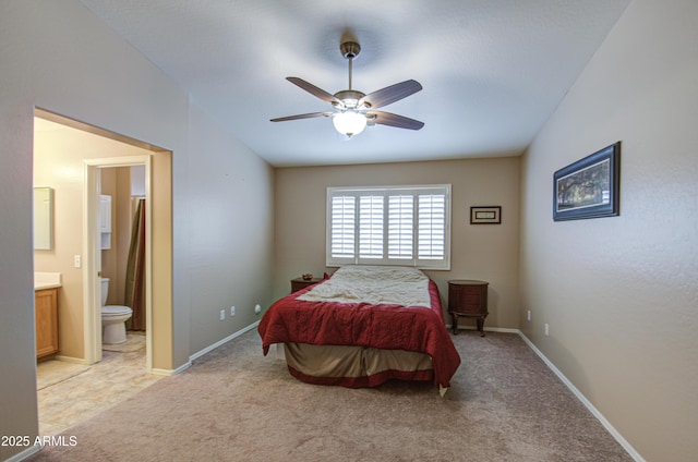 bedroom featuring vaulted ceiling, light colored carpet, baseboards, and connected bathroom