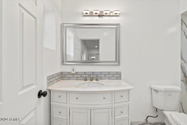 bathroom with decorative backsplash, toilet, and vanity