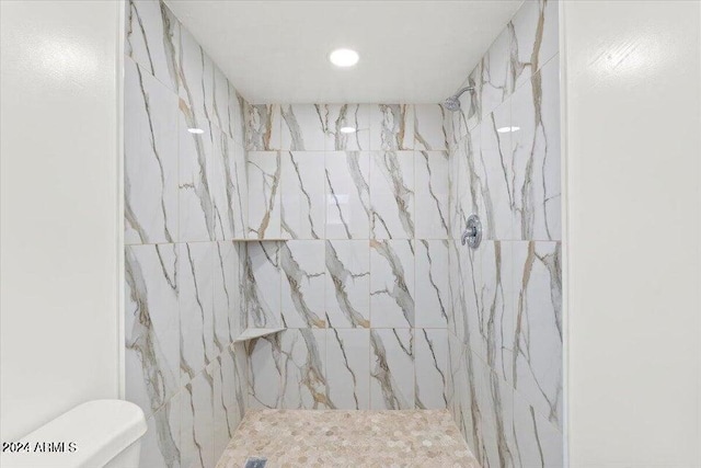 bathroom with tiled shower and toilet