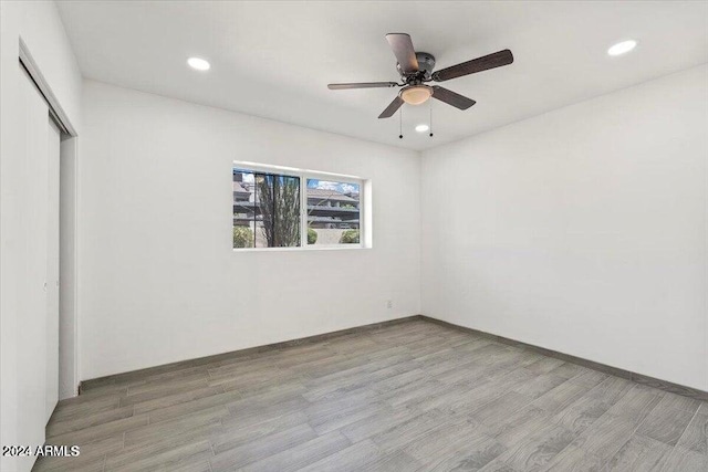 unfurnished bedroom featuring ceiling fan, light wood finished floors, a closet, and recessed lighting