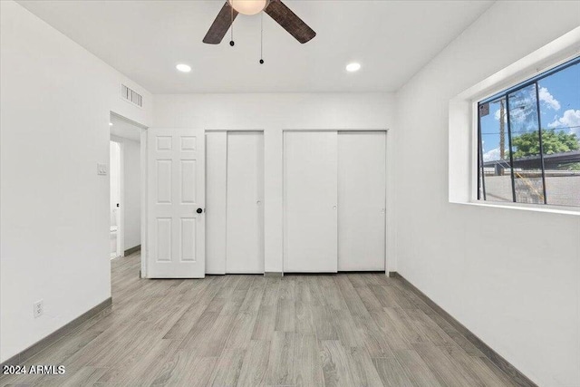 unfurnished bedroom featuring two closets, recessed lighting, visible vents, light wood-style flooring, and baseboards