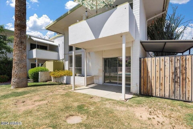 back of house with a patio area and a lawn