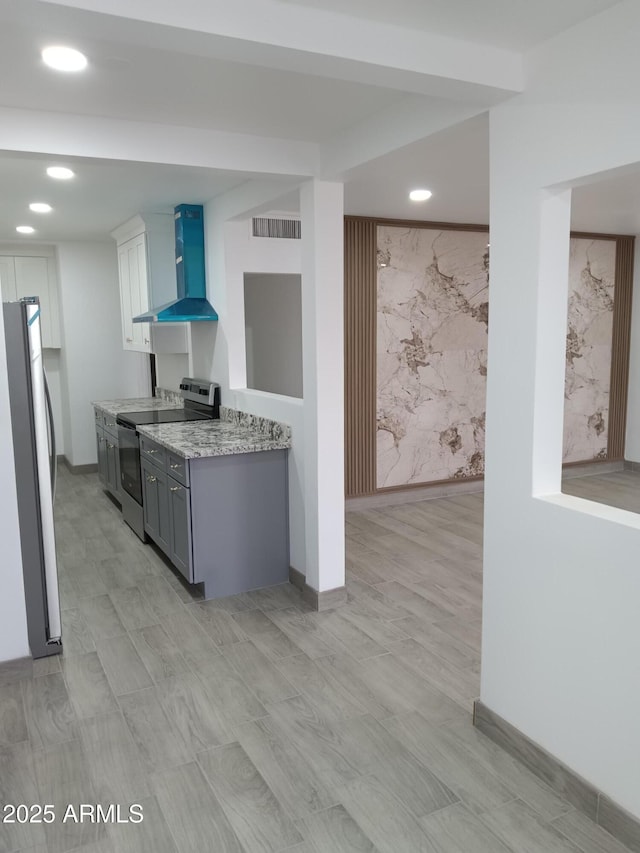 kitchen with visible vents, wall chimney exhaust hood, appliances with stainless steel finishes, light stone countertops, and recessed lighting