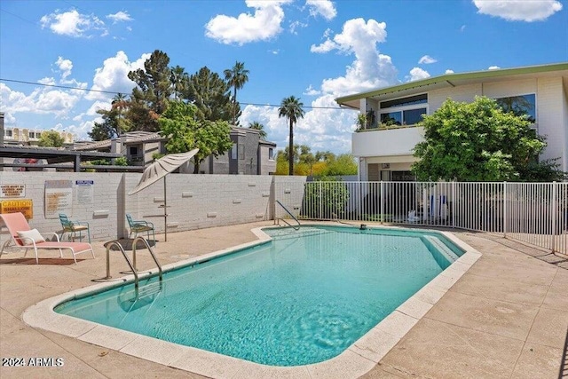 community pool featuring fence and a patio