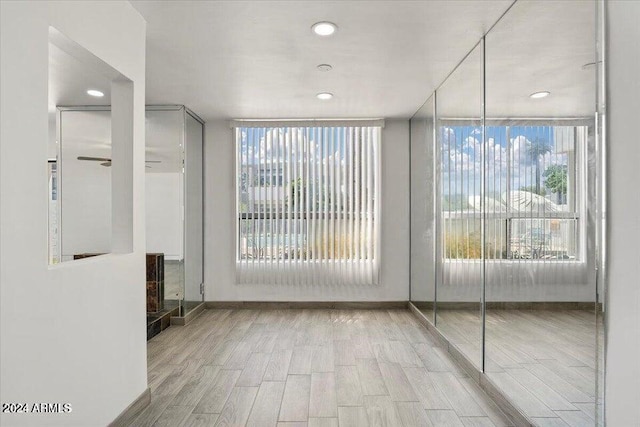 spare room with baseboards, recessed lighting, and light wood-style floors