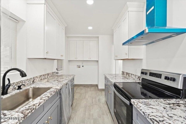 kitchen featuring white cabinetry, a sink, stainless steel range with electric stovetop, light wood-type flooring, and extractor fan