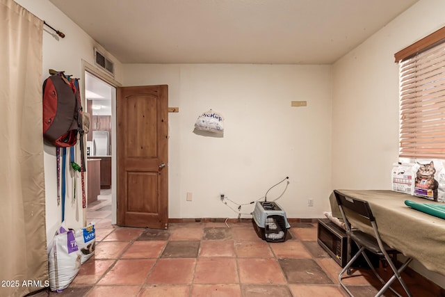 interior space with baseboards, visible vents, and stone tile flooring
