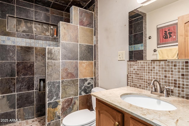 bathroom with vanity, walk in shower, backsplash, and toilet