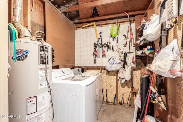 laundry room featuring washing machine and clothes dryer, a workshop area, and water heater