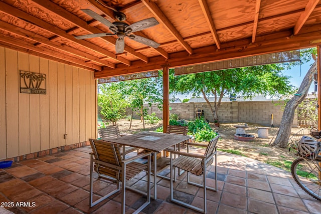 view of patio / terrace with outdoor dining area, a fenced backyard, and a ceiling fan
