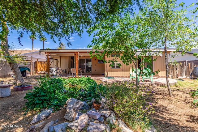 rear view of property featuring a patio area and fence