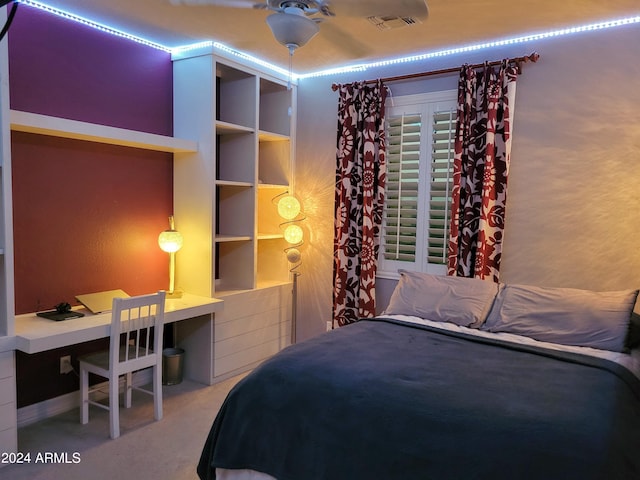 bedroom featuring carpet floors, built in desk, and visible vents