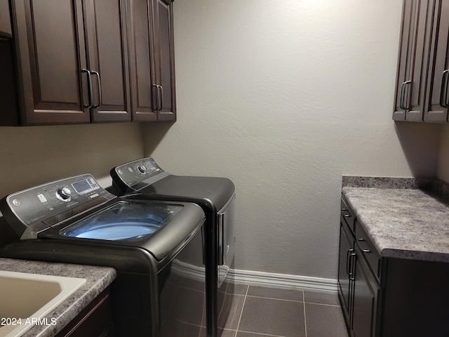 laundry area with a textured wall, a sink, baseboards, independent washer and dryer, and cabinet space