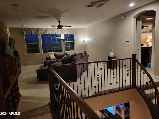 interior space featuring arched walkways, visible vents, an upstairs landing, and recessed lighting