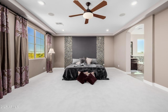 carpeted bedroom featuring arched walkways, baseboards, visible vents, and recessed lighting