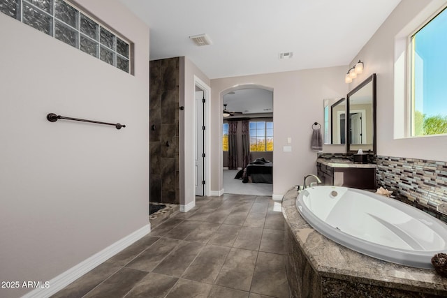 full bath with a garden tub, a ceiling fan, a tile shower, connected bathroom, and vanity