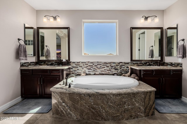 bathroom featuring a sink, two vanities, and a bath