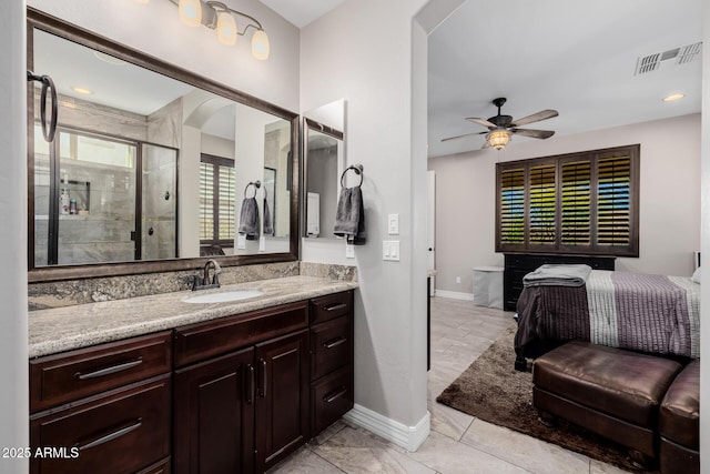 full bath featuring ceiling fan, vanity, visible vents, baseboards, and a shower stall